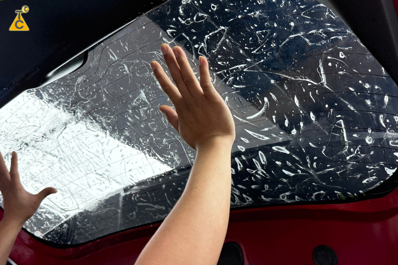 Kỹ thuật viên đang dán phim cách nhiệt 3M Crystalline cho kính hậu xe ô tô